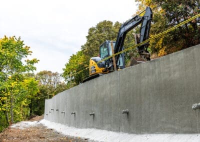 A medium shot of a new shotcrete soldier pile wall to support the embankment on a steep slope.