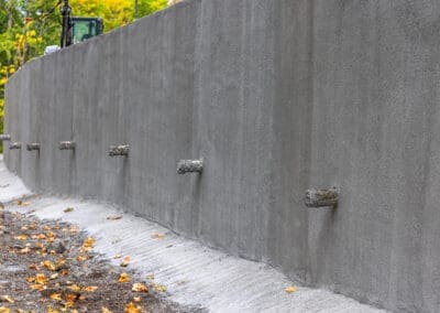 a close up shot of a new shotcrete soldier pile wall to support the embankment on a steep slope.