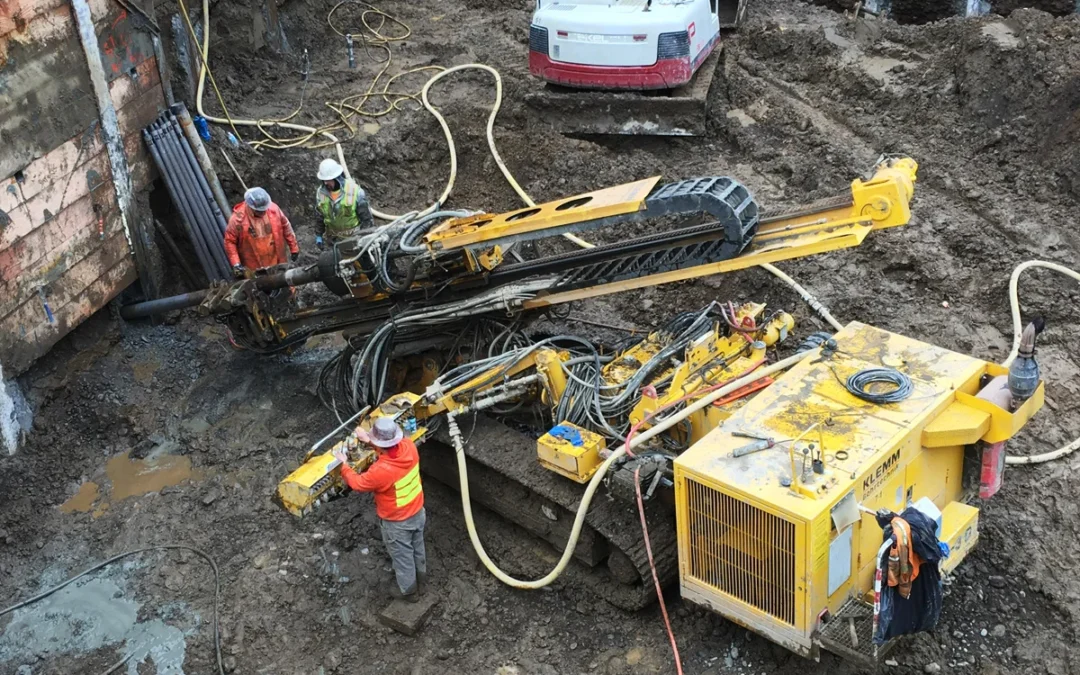 Pacific Foundation drillers operate a Klemm 806-3D to install tieback anchors on a construction project
