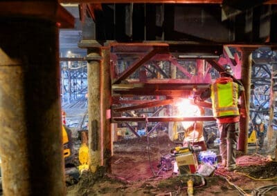 A welder fabricates a steel tower under the Oregon state capitol